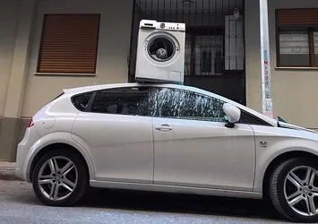 Çamaşır makinesini otomobilin üzerine attı
