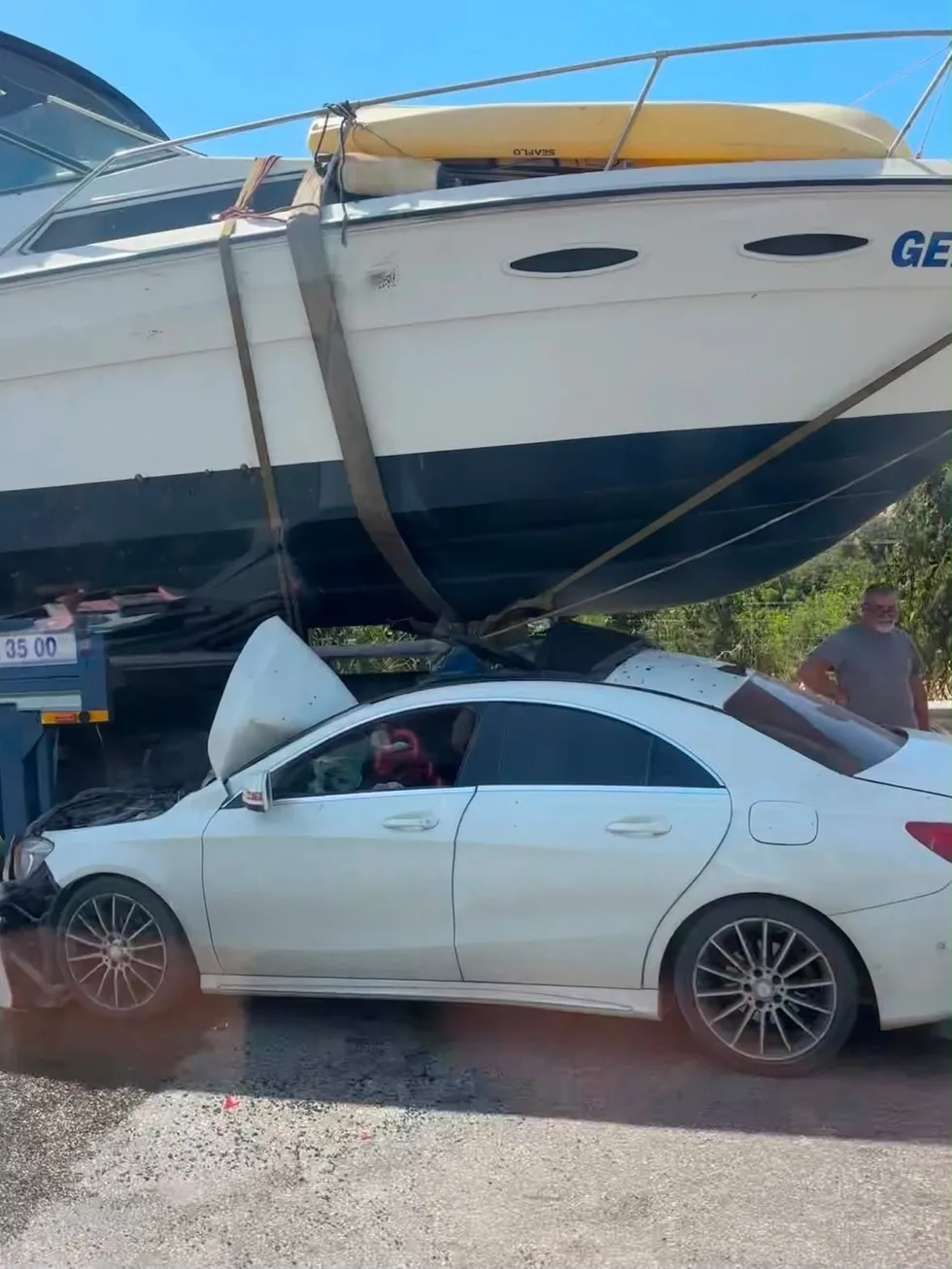 1785185044228.jpg İzmir-Çeşme Otoyolu'nda otomobil, çekiciyle taşınan teknenin altına girdi. (İHA)