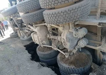 Yolun çökmesiyle kum yüklü kamyon devrildi