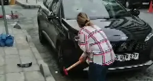Eşinin arabasına çekiçle saldırdı