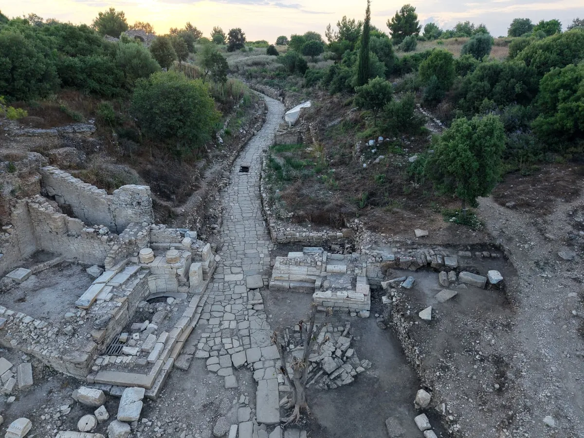 aspendosun-2-bin-yillik-tiyatro-caddesi-gun-yuzune-cikarildi-1784966741568.jpeg Fenike sikkesi ile cam alabastronlar, Aspendos’un Suriye-Filistin bölgesi ve Doğu Akdeniz’in deniz aşırı ticaret ağlarıyla bağlantısını belgeledi.