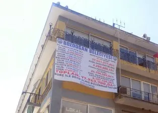 Devraldığı belediyenin borçlarını büyük bir afişle duyurdu