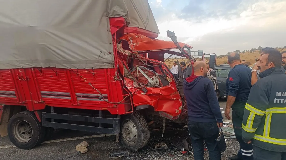 Kum yüklü kamyon minibüsün üzerine devrildi