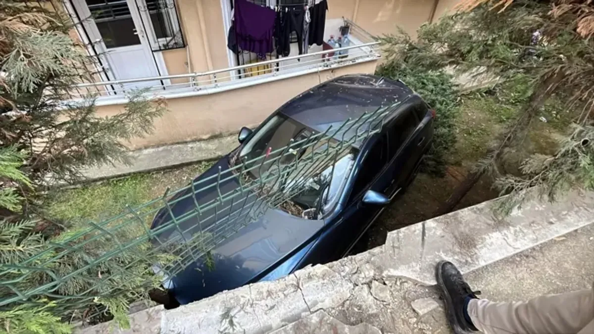 Otomobil duvarı aşıp binanın bahçesine düştü