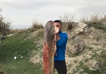 Boyundan büyük balık yakaladı