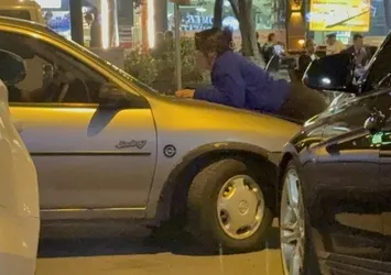 Kocasıyla tartışan kadın aracın kaputuna çıktı
