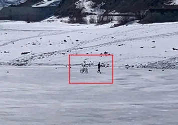 Buzla kaplı gölün üzerinde bisiklet sürdü