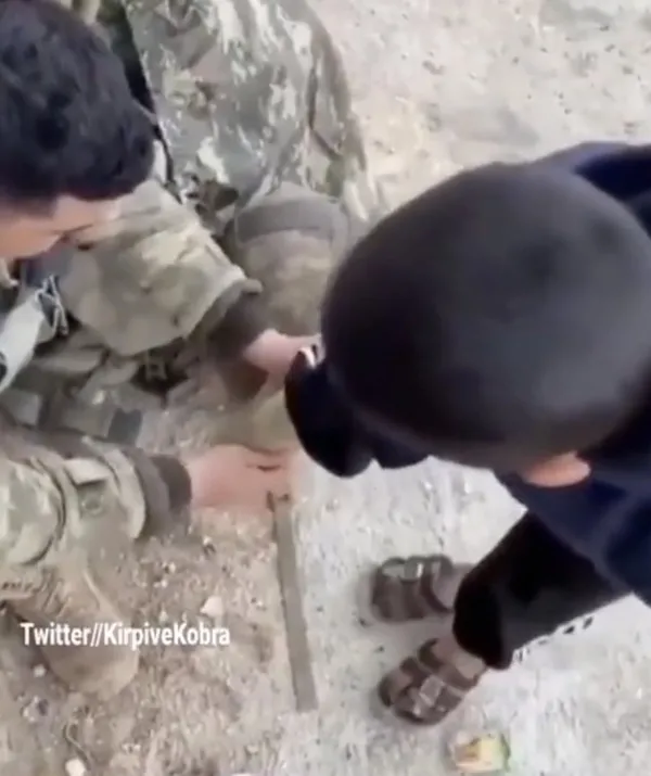 Yürek ısıtan görüntü! Mehmetçik çorapsız çocuğa kendi çorabını giydirdi