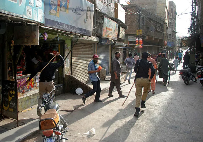 Pakistan polisi sokağa çıkma yasağına uymayanları sopayla dövdü - 1