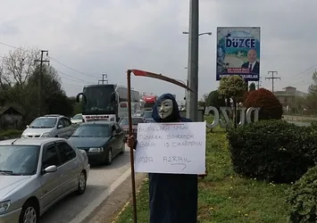 D-100'da garip eylem! Maske takıp pankartla yola çıktı