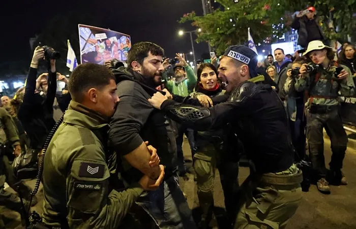 bibi-hukumetini-israilli-siyonistler-mi-devirecek-savasin-maliyetleri-adeta-bogazlarina-dayandi-1736074007767.jpg 4 Ocak 2025'te İsrail'in Tel Aviv kentinde, İsrail ile Hamas arasında Gazze'de devam eden çatışmanın ortasında, 7 Ekim 2023'teki ölümcül saldırı sırasında kaçırılan rehinelere destek göstermek için hükümete yönelik bir protesto sırasında güvenlik güçleri üyeleri bir protestocuyu yakasından tutuyor (Reuters)